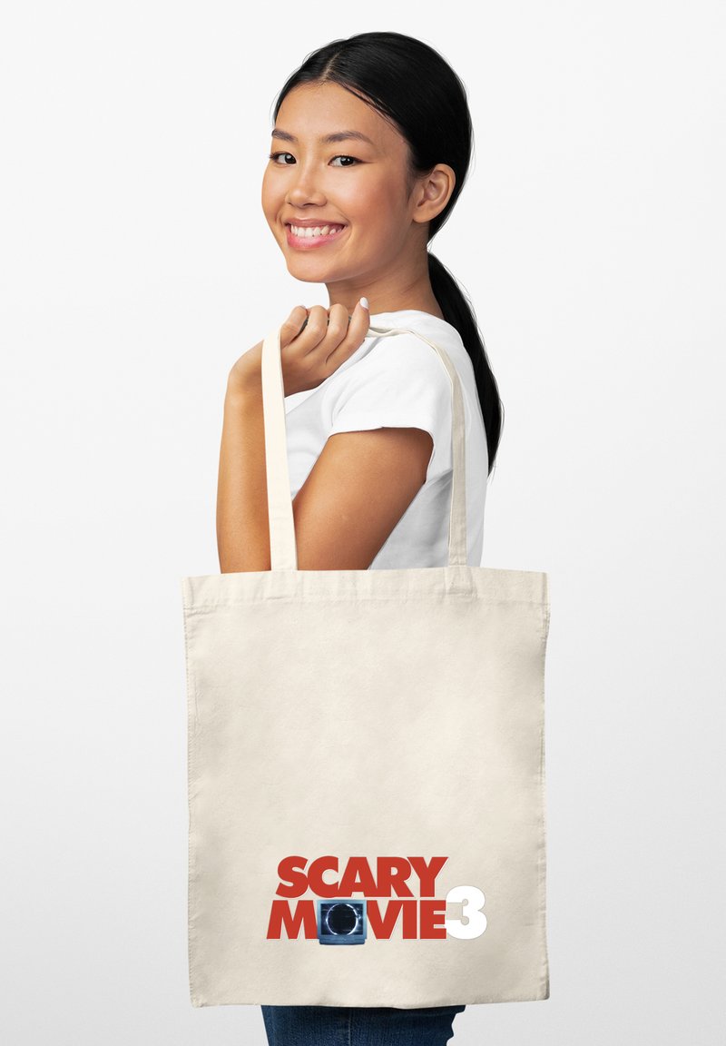 Bolsa de lona de color crema con el texto "SCARY MOVIE 3" en rojo negrita, acompañado de un elemento gráfico azul. Diseño grande y resistente.
