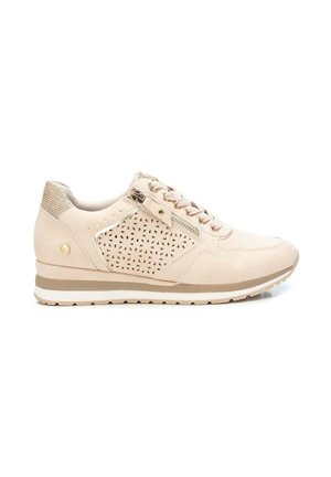 Zapatilla beige con cordones delanteros, panel lateral perforado, detalle de cremallera y suela de goma a rayas, vista desde el lado exterior.