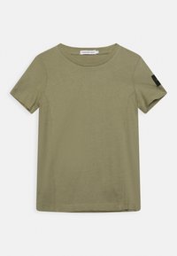 T-shirt a maniche corte di colore verde oliva, realizzato in tessuto morbido, con colletto rotondo e una piccola etichetta nera su una manica.