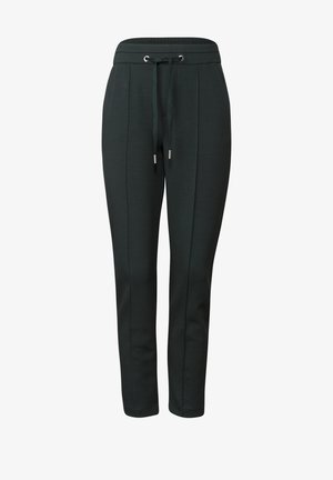 Pantalons de survêtement vert foncé avec une taille à cordon de serrage, jambes effilées, détails de couture latérale et accents métalliques aux extrémités du cordon de serrage.