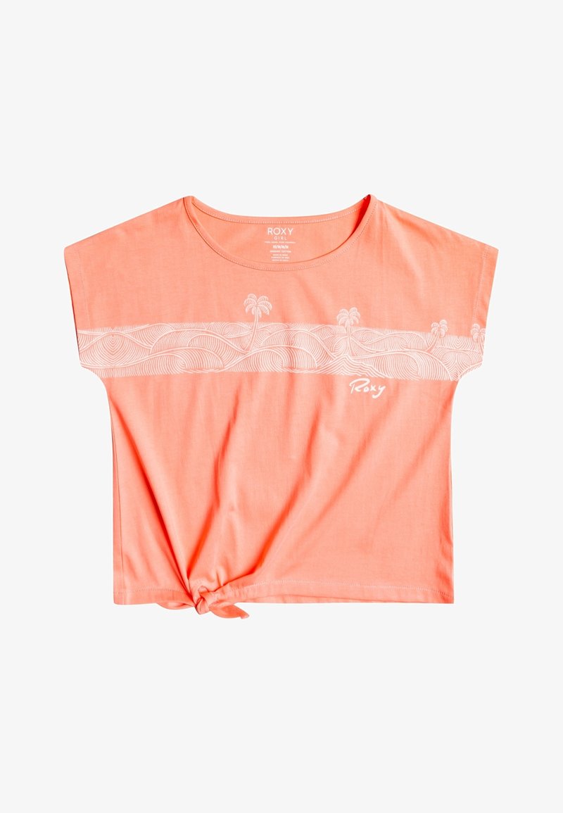 T-shirt court rose corail avec nœud à l’ourlet, motif abstrait blanc de vagues et de palmiers sur la poitrine, et logo "Roxy" sur le devant.