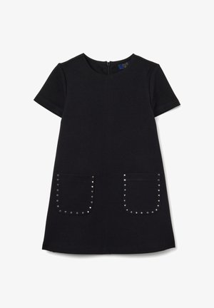 Vestido corto negro de manga corta con escote redondo, que presenta dos bolsillos frontales adornados con tachuelas plateadas. Cierre de cremallera en la parte posterior, textura de tela suave.