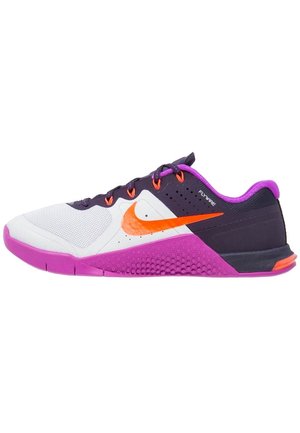 Chaussure de sport à profil bas avec avant en mesh blanc, dessus noir et violet, logo Nike orange vif et semelle violette avec section médiane texturée.