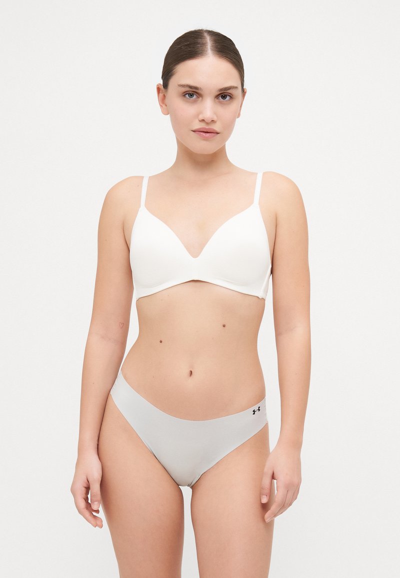 Witte driehoek bralette met verstelbare bandjes en zachte stof, gecombineerd met grijze naadloze bikini slipjes met een zwart logo aan de zijkant.