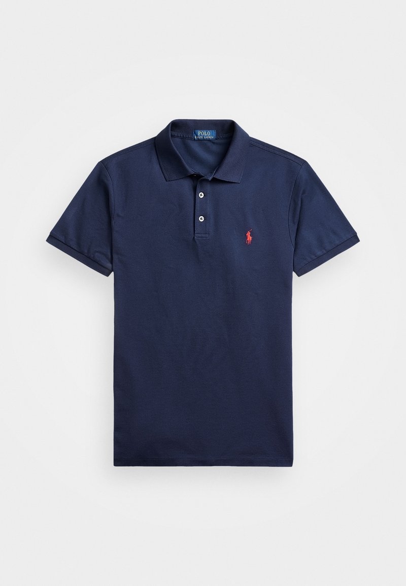 Polo de color azul marino de algodón, con cuello, tapeta de tres botones y logotipo rojo bordado en el lado izquierdo del pecho. Manga corta.