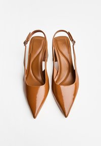 Korkean kantapään ruskeat lakatut slingback-kengät, joissa on terävä kärki, sileä pinta ja pehmustettu pohja. Mukana säädettävä nilkkahihna.