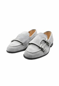 Mocassini in suede grigio con doppi accessori a fibbia, dettagli di cucitura laterale, punta tondeggiante e suola nera. Fodera interna in pelle liscia.