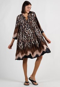 Leopardenmuster-Kleid mit V-Ausschnitt, Dreiviertelärmeln und gestuftem Rock. Hergestellt aus leichtem Stoff in Braun- und Schwarztönen.