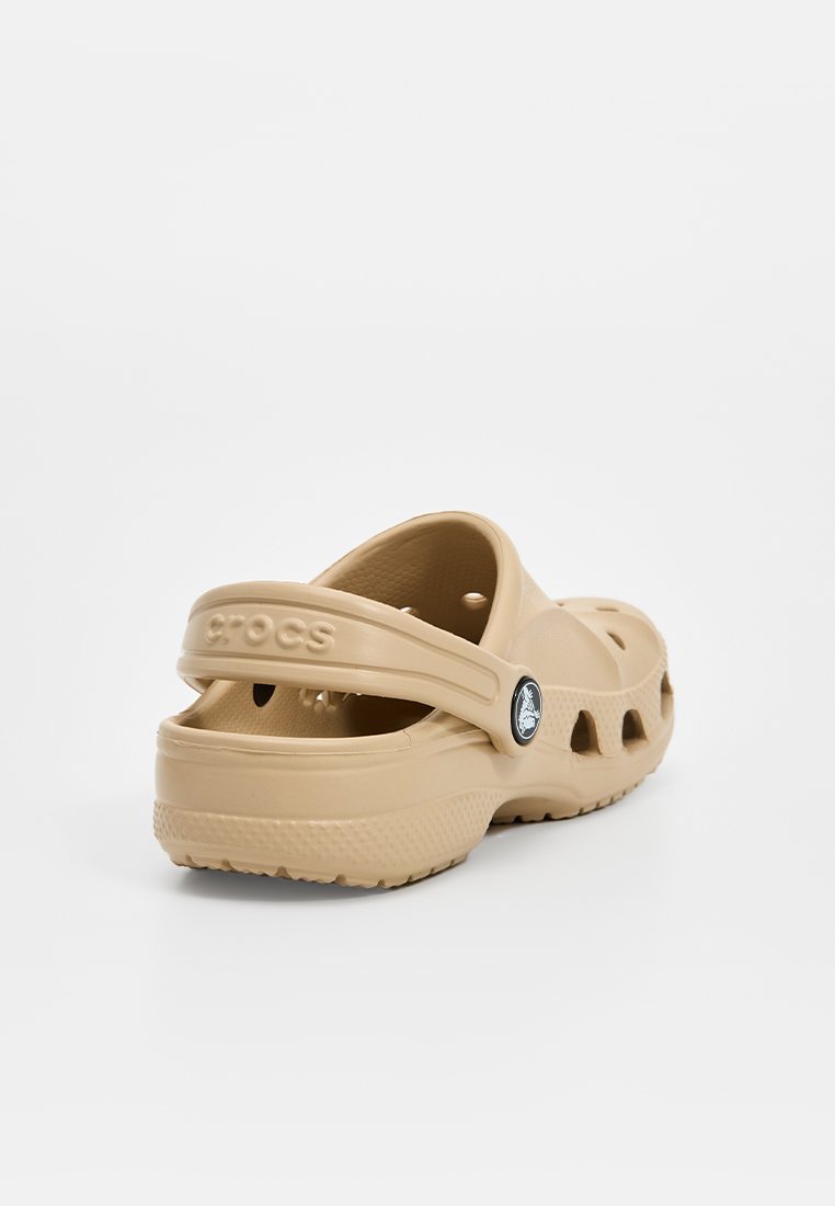 Casual beige klompen gemaakt van lichtgewicht materiaal, met ventilatiegaten, een verstelbare hielband en een ronde logodetail.
