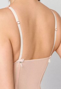 Jasnoróżowy bodysuit z koronkowymi detalami, z delikatnymi ramiączkami i regulowanym zapięciem. Miękka, przezroczysta tkanina o gładkiej fakturze.