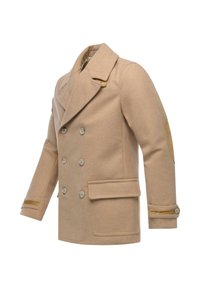 Piumino di lana doppiopetto in beige con ampi risvolti, grandi bottoni, tasche frontali e toppe marroni sui gomiti. Tessuto liscio, vestibilità strutturata.