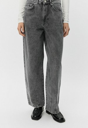 Szürke, magas derekú, széles lábú farmernadrág, elmosott mosással, elülső zsebekkel és gombos záródással. Lazán illeszkedő, egyenes sziluettel rendelkezik.