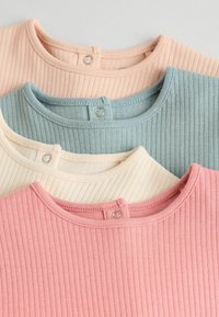 Fyra ribbade T-shirt-kragar i mjuka pastellfärger: ljusrosa, blekblå, krämvit och beige, med tryckknappar på baksidan.