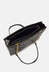 Sac à main matelassé noir en cuir, équipé de ferrures dorées, avec deux poches zippées à l'intérieur, et deux anses (une chaîne, une lisse).