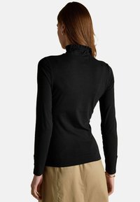 Čierny dlhý rukáv s vysokým golierom s volánkovými detailami. Hladká textúra, priliehavý strih a jemne strihané rukávy.