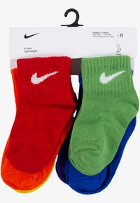 Pakiranje šestih večbarvnih nogavic za malčke: rdeča, oranžna, rumena, zelena, modra, vijolična. Mehka pletenina z rebrastimi manšetami in belim logotipom Nike.