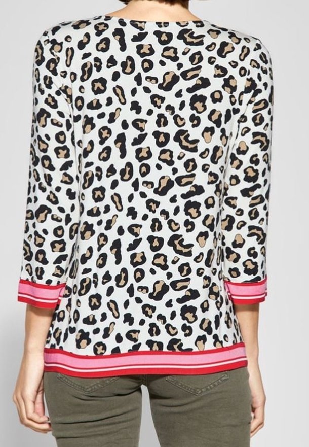 Top med leopardmönster och trekvartsärmar, vit botten med svarta och bruna fläckar och rödrandig nederkant. Slät tyg och avslappnad passform.