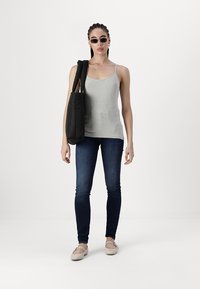 Harmaa hihaton tank top, tummansiniset kapeat farkut, musta olkalaukku ja vaaleat ballerinat. Asusteina tummat aurinkolasit ja korvakorut.