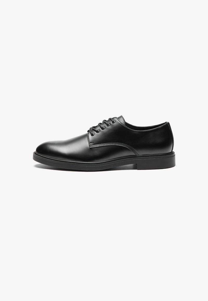 Black leather dress shoe with a smooth finish, rounded toe, six eyelet lace-up design, and a flat rubber sole.