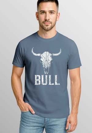 Blue short-sleeve t-shirt featuring a white bull skull graphic and the word "BULL" in distressed font. Made of soft cotton fabric.