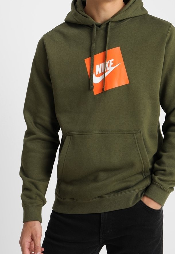 Olivgrön hoodie i mjukt material, med en framficka i kangurostil och en orange Nike-logotyp på en fyrkantig dyka. Justerbar huva.