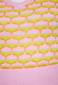 Pletený svetr s hexagonálním vzorem v růžové, žluté a oranžové barvě. V-dekolt s ribbovaným růžovým lemem a strukturovanou tkaninou.