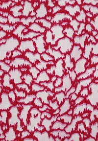 Rot-weißer Stoff mit einem strukturierten Muster, das abstrahierte, wellenförmige Linien und Formen auf einem leichten Material zeigt.