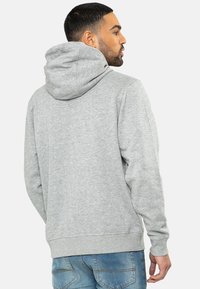 Grijze sweatshirt met capuchon en kenguruzak, geribbelde manchetten en zoom, gemaakt van een zachte stof; heeft een simpel ontwerp en een ontspannen pasvorm.