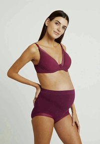 Raskauden aikana käytettävä rintaliivi ja korkeat alushousut syvän burgundin värissä. Pehmeä kangas, jossa pitsikoristelu rintaliivissä. Sileä pinta ja mukava istuvuus.