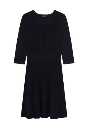 Robe en tricot noire avec une texture côtelée, un bodice ajusté et une jupe évasée ornée d'une bordure en zigzag décorative à la taille. Manches trois-quarts.