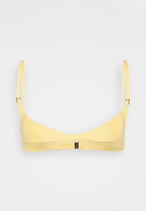Bralette jaune en tissu lisse. Présente des bretelles fines et réglables, un design minimaliste et une fermeture à agrafes dans le dos.