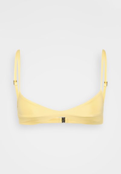 Bralette giallo realizzato in tessuto morbido. Presenta spalline sottili e regolabili, un design minimalista e una chiusura a gancio sul retro.