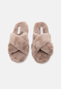 Mākslīgās kažokādas čības gaišā bēšā krāsā ar krustveida dizainu. Mīksta tekstūra ar greznu izskatu un plakana zole komfortam.