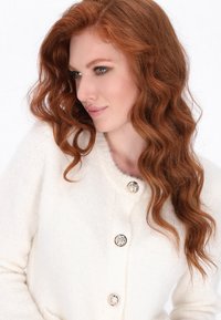 Crème-kleurige cardigan van zachte stof, met een ronde halslijn, vijf decoratieve knopen en geribde manchetten.