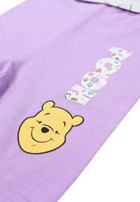 Tissu lavande avec un visage de ours jaune souriant en bas et des lettres colorées et décorées épelant "COOL" au-dessus.