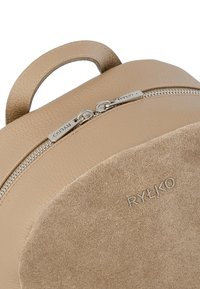 Beige leren en suède rugzak met zilveren rits en de merknaam Ryłko op de voorzak.
