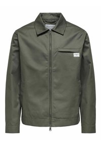 Chaqueta verde oliva hecha de una tela suave, con cierre frontal, cuello puntiagudo y un único bolsillo en el pecho con una etiqueta.