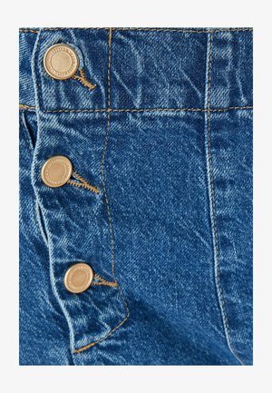 Denimstof in een rijke blauwe tint, met drie metalen knopen en contrasterend gele stiksels langs de naden en het zakgebied.