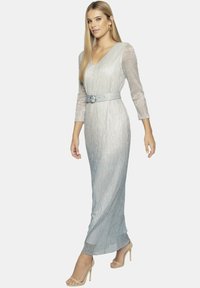 Srebrna metaliczna sukienka z dekoltem w serek, trzy czwarte rękawami i dopasowanym talią podkreśloną pasującym paskiem oraz małą okrągłą klamrą.