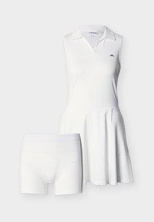 Valkoinen hihaton mekko, jossa on kauluksellinen pääntie ja laskostettu hame, yhdistettynä samanvärisiin valkoisiin shortsseihin, joissa on vartalonmyötäinen istuvuus.