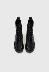 Must have mustad must be leather boots with chunky solad italiani sueed zippers, which bright on a puht white backgroud.