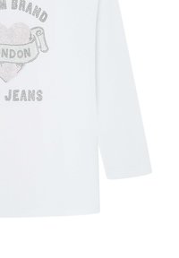 Valkoinen pitkähihainen paita, jossa on pyöreä pääntie, tahrattomasti koristeltu teksti: "BRAND LONDON JEANS" ja sydämen grafiikkasuunnittelu.