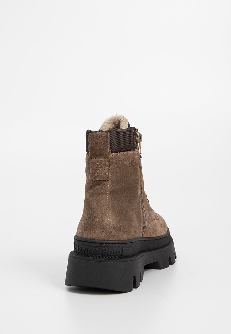 Bottines en daim marron avec une finition texturée, dotées d'une fermeture éclair latérale, d'une doublure en fourrure et d'une semelle en caoutchouc noir épaisse.