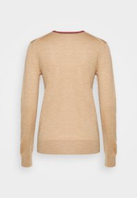 Beige Pullover mit langen Ärmeln und glatter Textur, mit Rundhalsausschnitt und einem kontrastierenden roten Akzent entlang des Kragens.