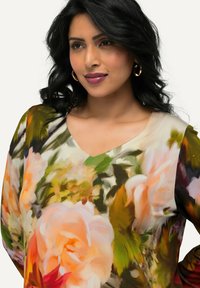 Halenka s květinovým vzorem, lehká s výstřihem do V, s velkými růžovými a oranžovými růžemi na jemné, texturované tkanině.