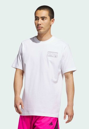 Hvid bomulds T-shirt med korte ærmer, rund halsudskæring og trykt sort grafik på venstre bryst. Glat tekstur, standart pasform.