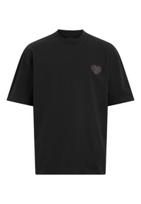 Camiseta de algodón negra con cuello redondo y mangas cortas, con un pequeño diseño en forma de corazón en la zona del lado izquierdo del pecho.