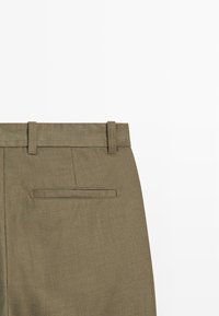 Olive green trousers with a smooth texture, featuring belt loops and a single back pocket with a horizontal opening. Tailored design.