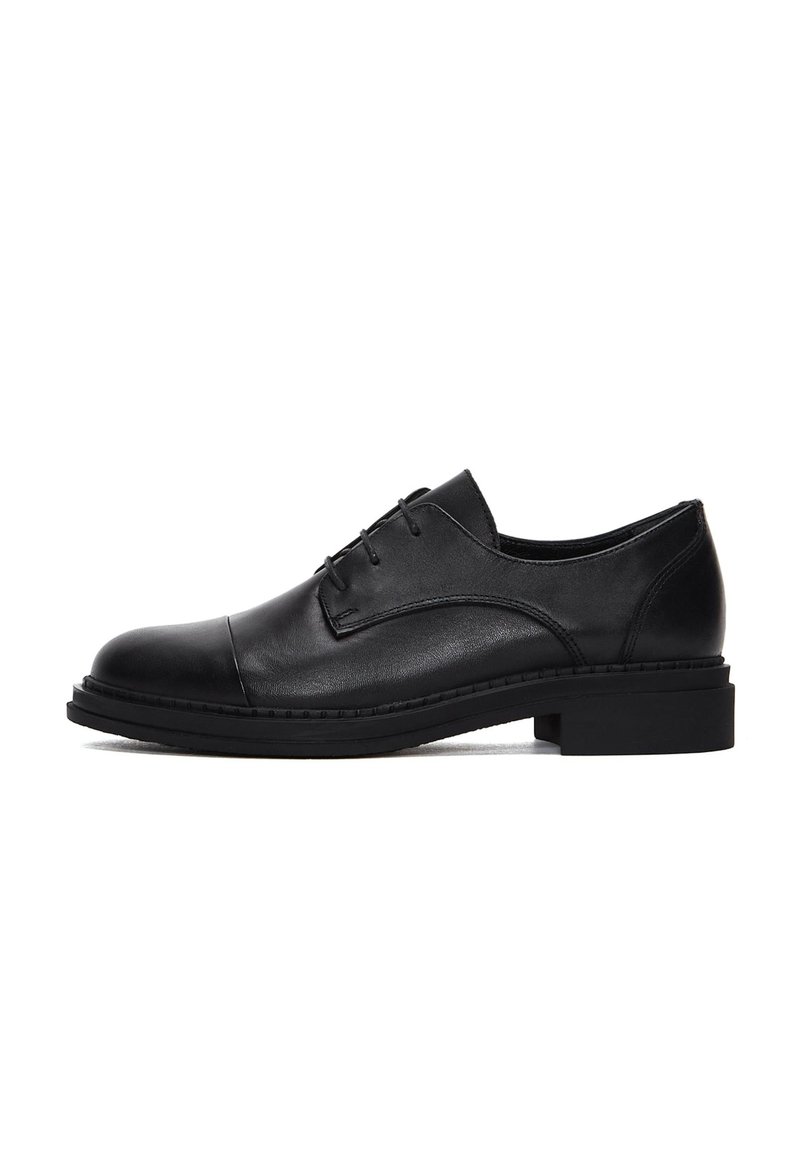 Chaussure habillée en cuir noir avec un bout arrondi et un laçage. Dotée d'une semelle en caoutchouc noir épaisse et d'une texture lisse. Accents de couture minimaux.