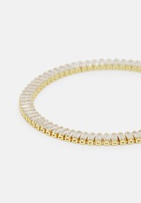Collana in tono oro con una fila continua di pietre rectangulari trasparenti, ciascuna montata in un supporto a staffa, con una finitura liscia.